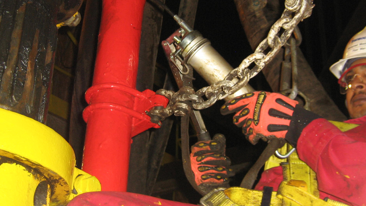 Worker at height with grease gun attached to dirty lanyard. Are the lanyards in your tethered tool kit permanently attached?